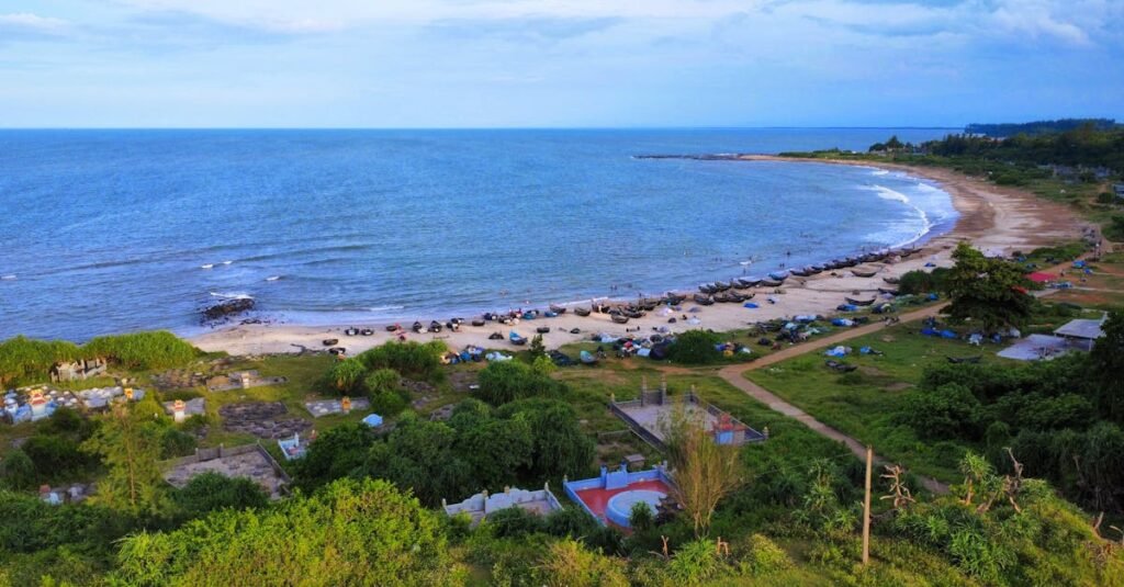 A scenic aerial view of a beach with boats along the shore, offering a calm retreat.